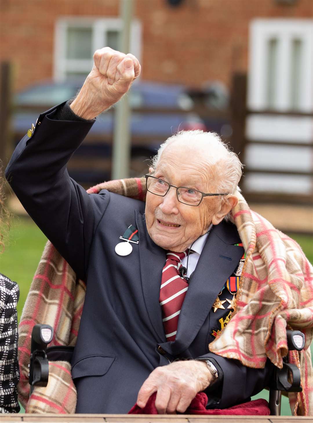 Captain Tom Moore waves to a Battle of Britain Memorial Flight flypast of a Spitfire and a Hurricane passing over his home as he celebrates his 100th birthday. (Emma Sohl/ Capture The Light Photography/ PA)