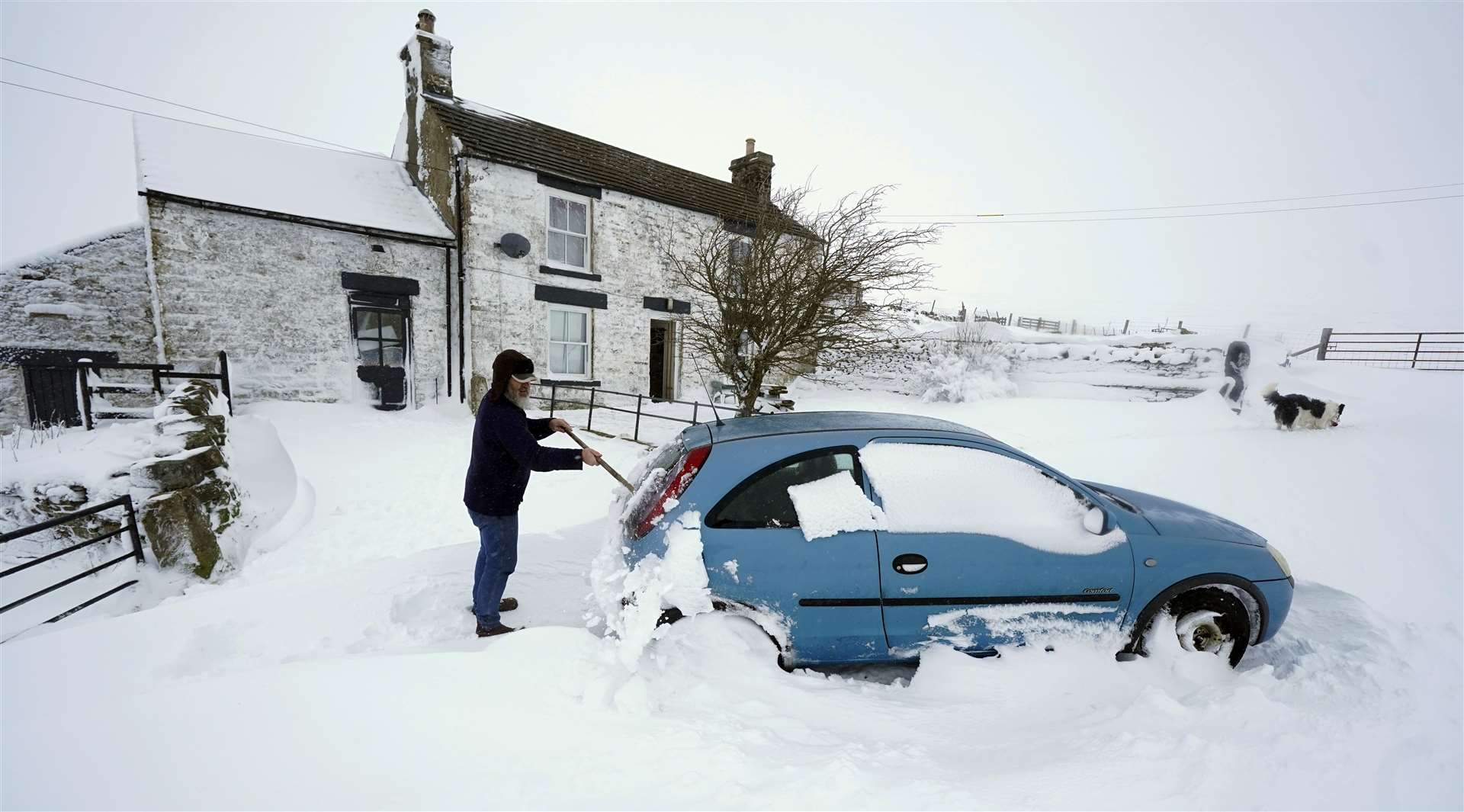 Johan Brand clears the snow from her car in the village of Harwood in Teesdale, Durham (Owen Humphreys/PA)