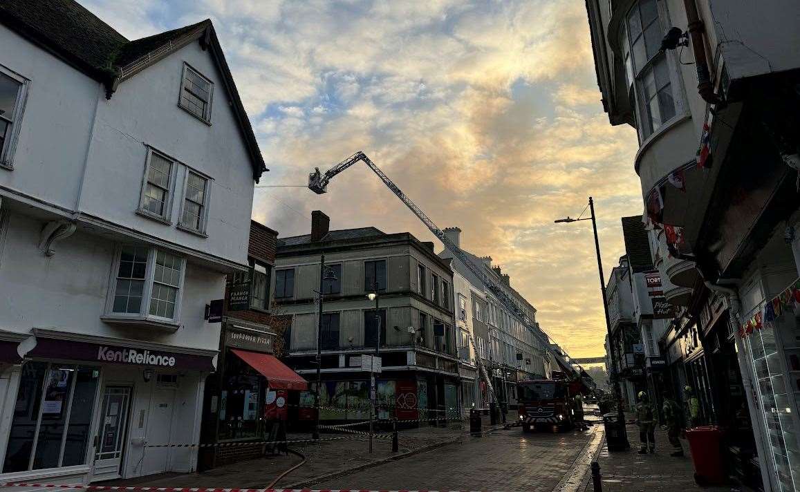 Crews remain at the scene of the former Debenhams fire in Canterbury this morning