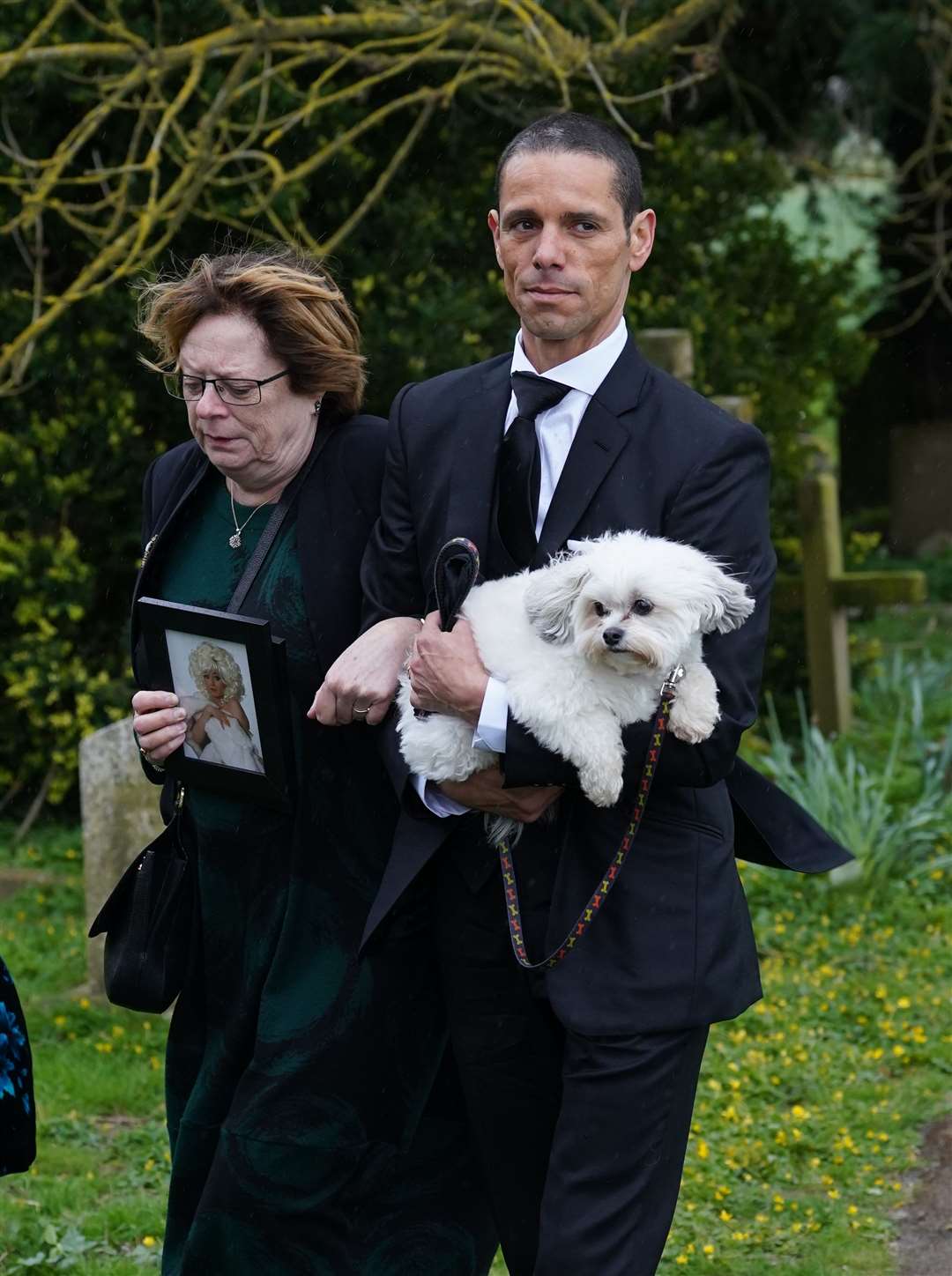 Andre Portasio carries one of their dogs, Conchitta (Gareth Fuller/PA)