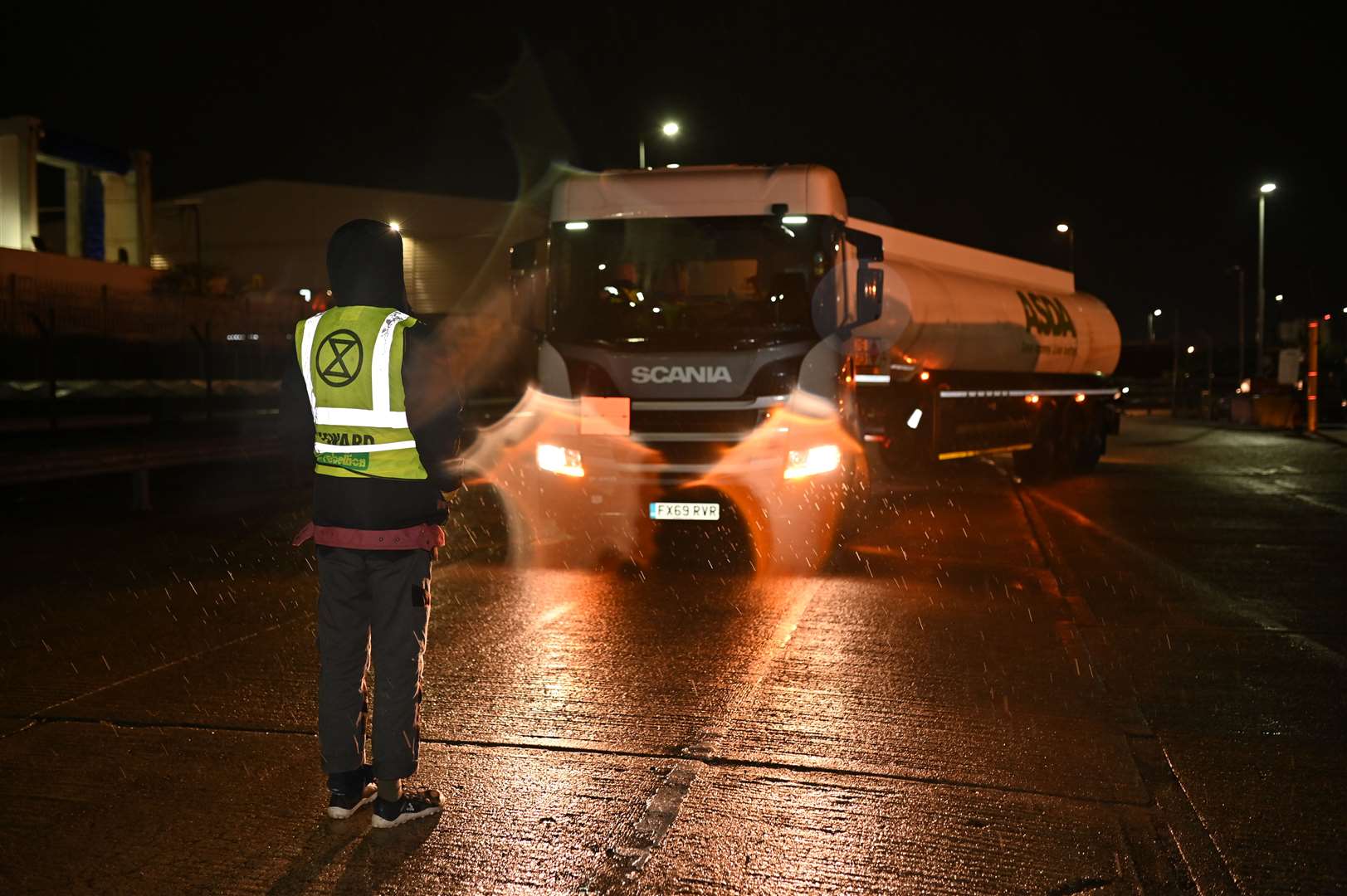 A campaigner stands in front of a tanker at the west London facility (Extinction Rebellion/PA)