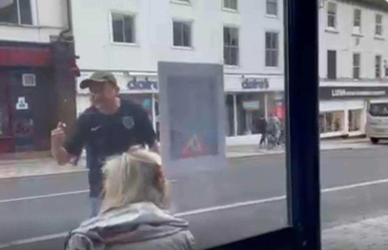 A protester berates people sat at a bus stop. Picture: Louis Hayward