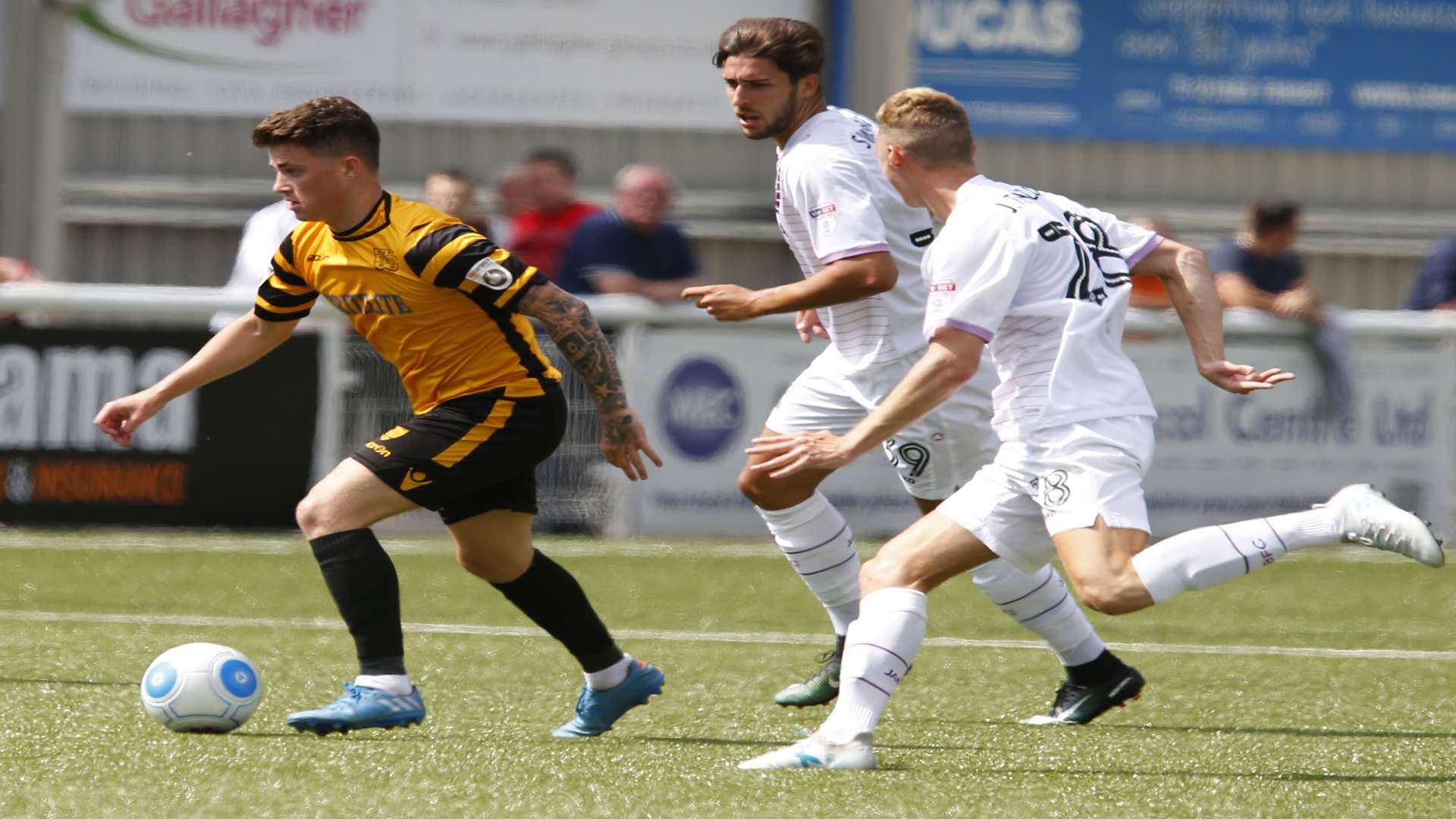 Jack Paxman in possession for Maidstone, tracked by former team-mate Dan Sweeney Picture: Andy Jones