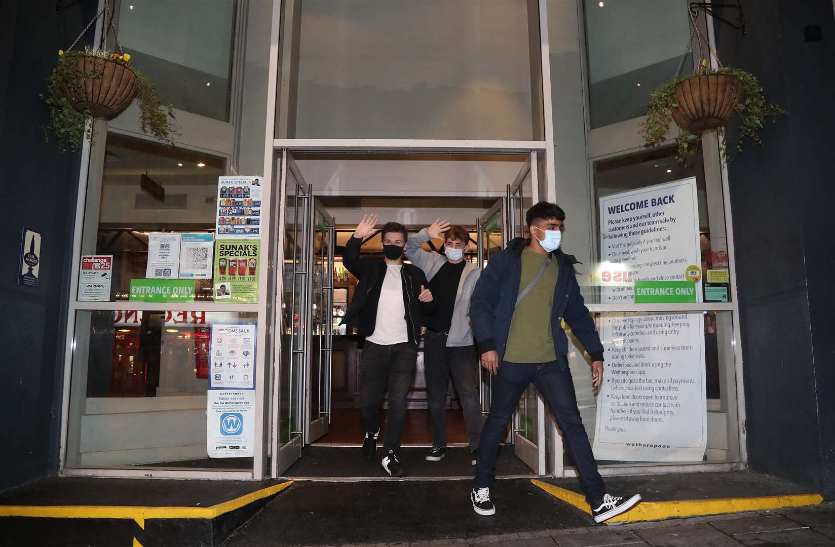 People leave a Wetherspoons pub in Brighton as the curfew comes into place (Gareth Fuller/PA)