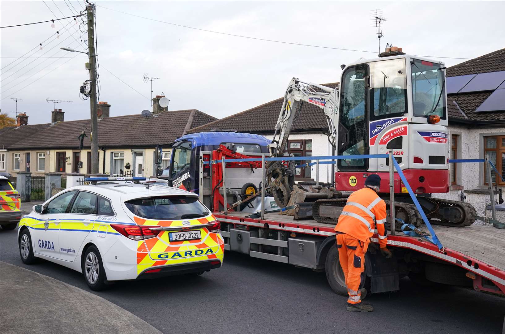 A mechanical digger used by Gardai leaves the area as a search of waste ground continues behind a house in Dundalk, Co Louth, in the investigation into the suspected murder of eight-year-old Kyran Durnin (Brian Lawless/PA)