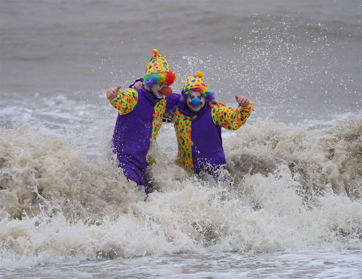 Swimmers Perry Springate and Chris Johnson dressed as clowns for their Christmas dip (Joe Giddens/PA)