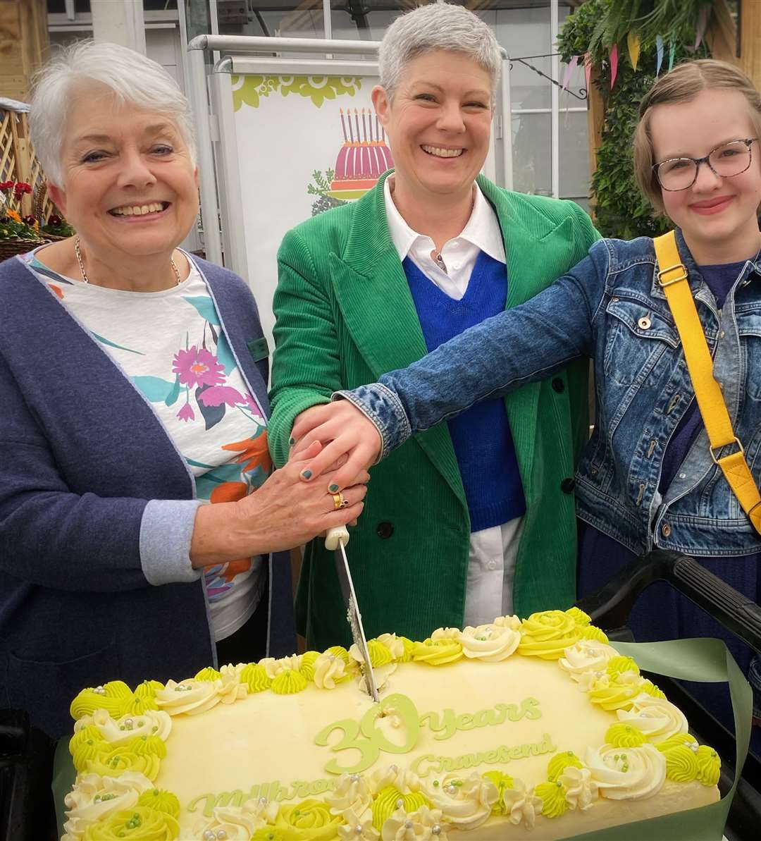 Three generations of Millbrook cutting the 30th birthday celebration cake at Millbrook Gravesend. Left to right: Founder and Chairman of Millbrook Garden Company, Sue Allen, with her daughter, Tammy Woodhouse (Millbrook’s Managing Director) and granddaughter, Ellie. Photo: Millbrook Garden Company