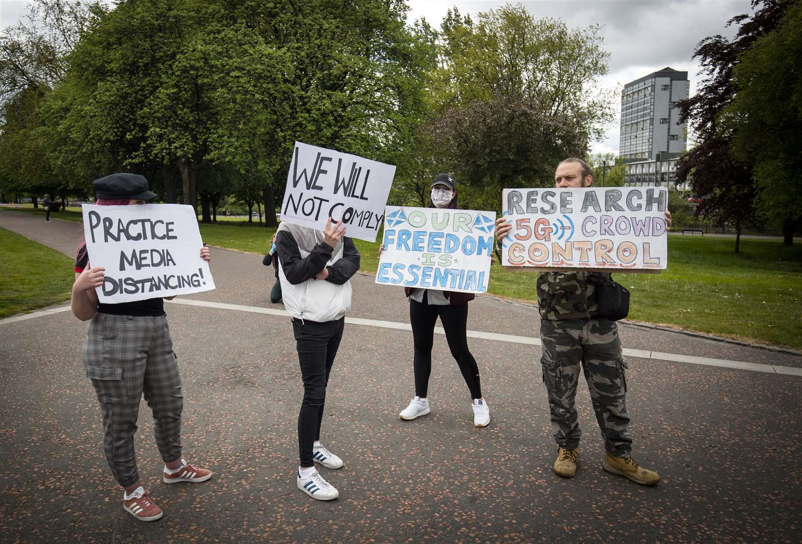 Members of the public hold signs at the Glasgow protest (Jane Barlow/PA)