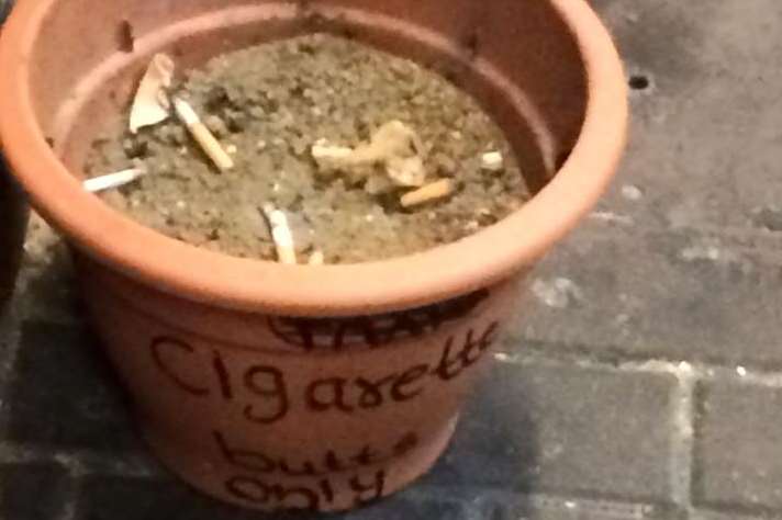 The terracotta fag pot left for smokers outside the station
