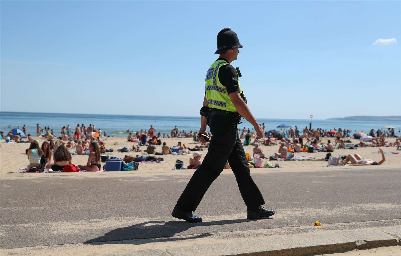 A police officer patrols along the beach in Bournemouth (Andrew Matthews/PA)