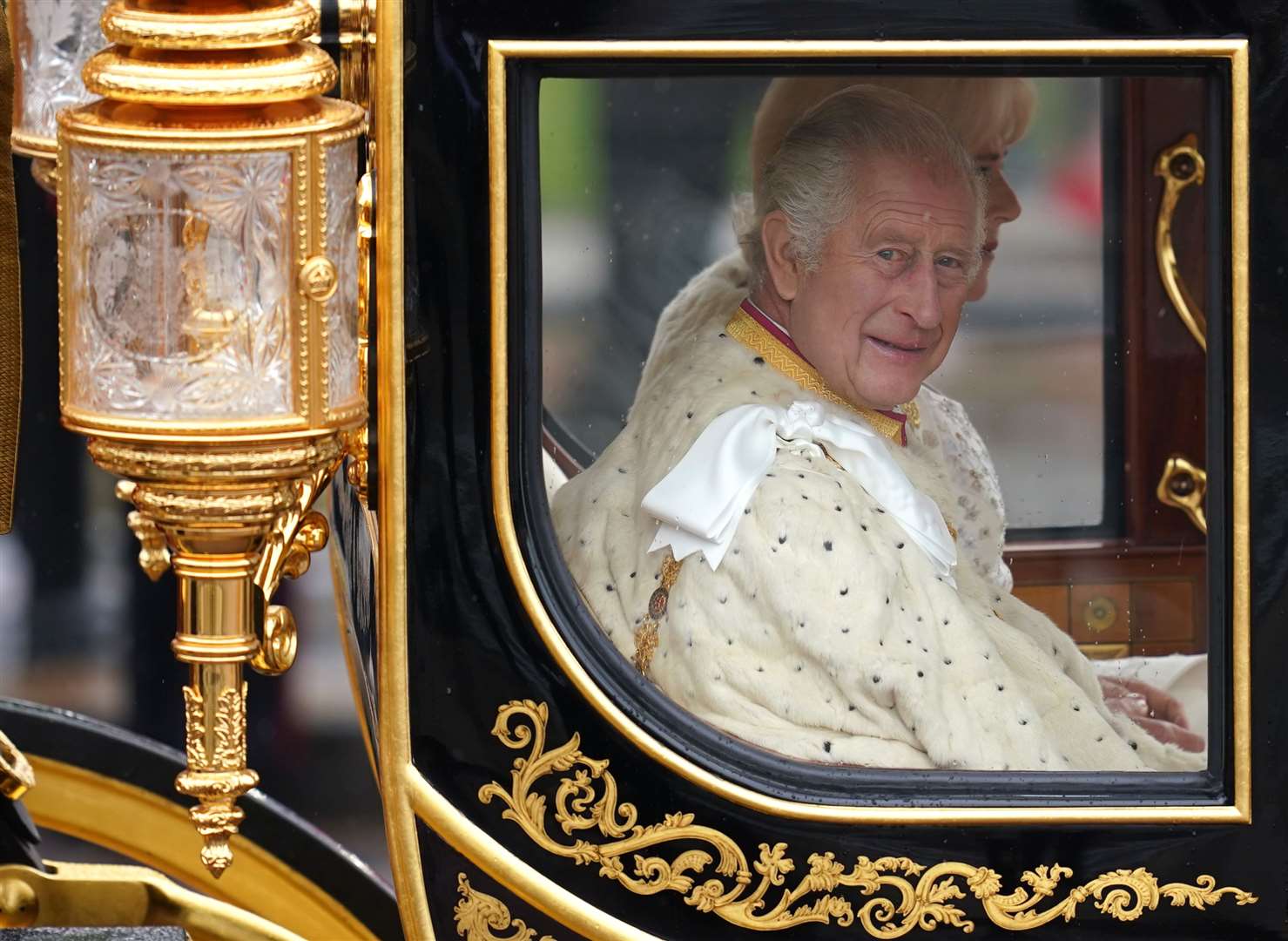 The King and Queen are carried in the Diamond Jubilee State Coach as the King’s Procession passes along The Mall to their coronation ceremony (Niall Carson/PA)