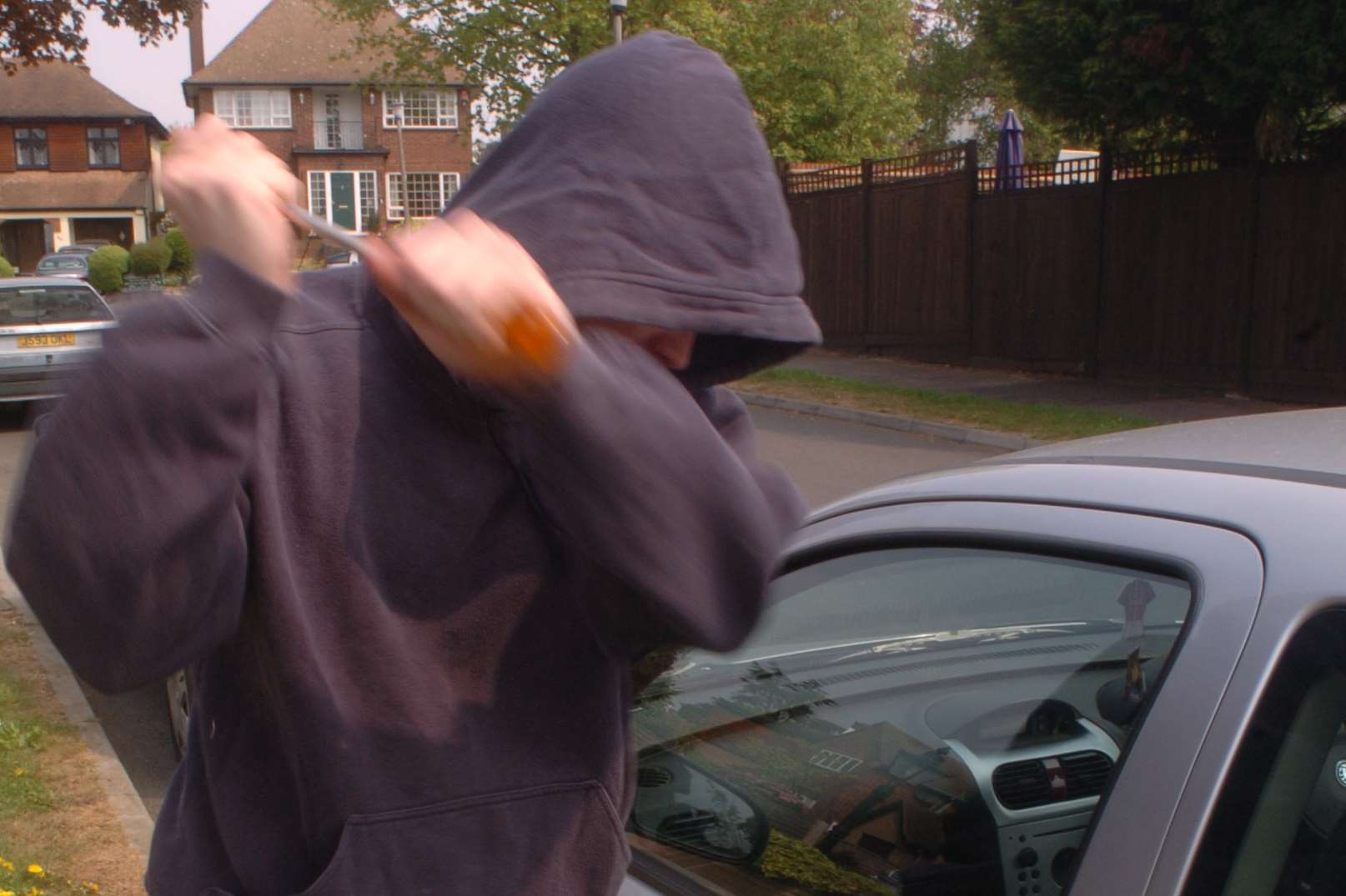 Image of yob breaking into car. Mock-up library photo