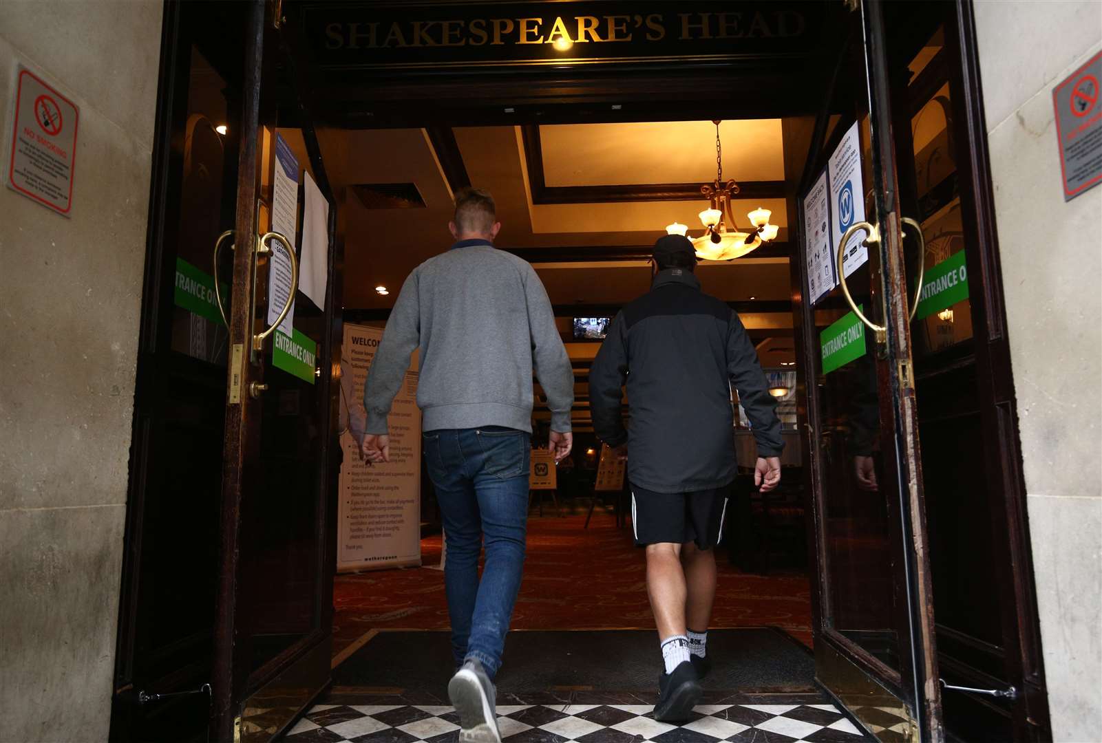 Customers walk into the Shakespeare’s Head pub in Holborn, London, as it reopens (Yui Mok/PA)