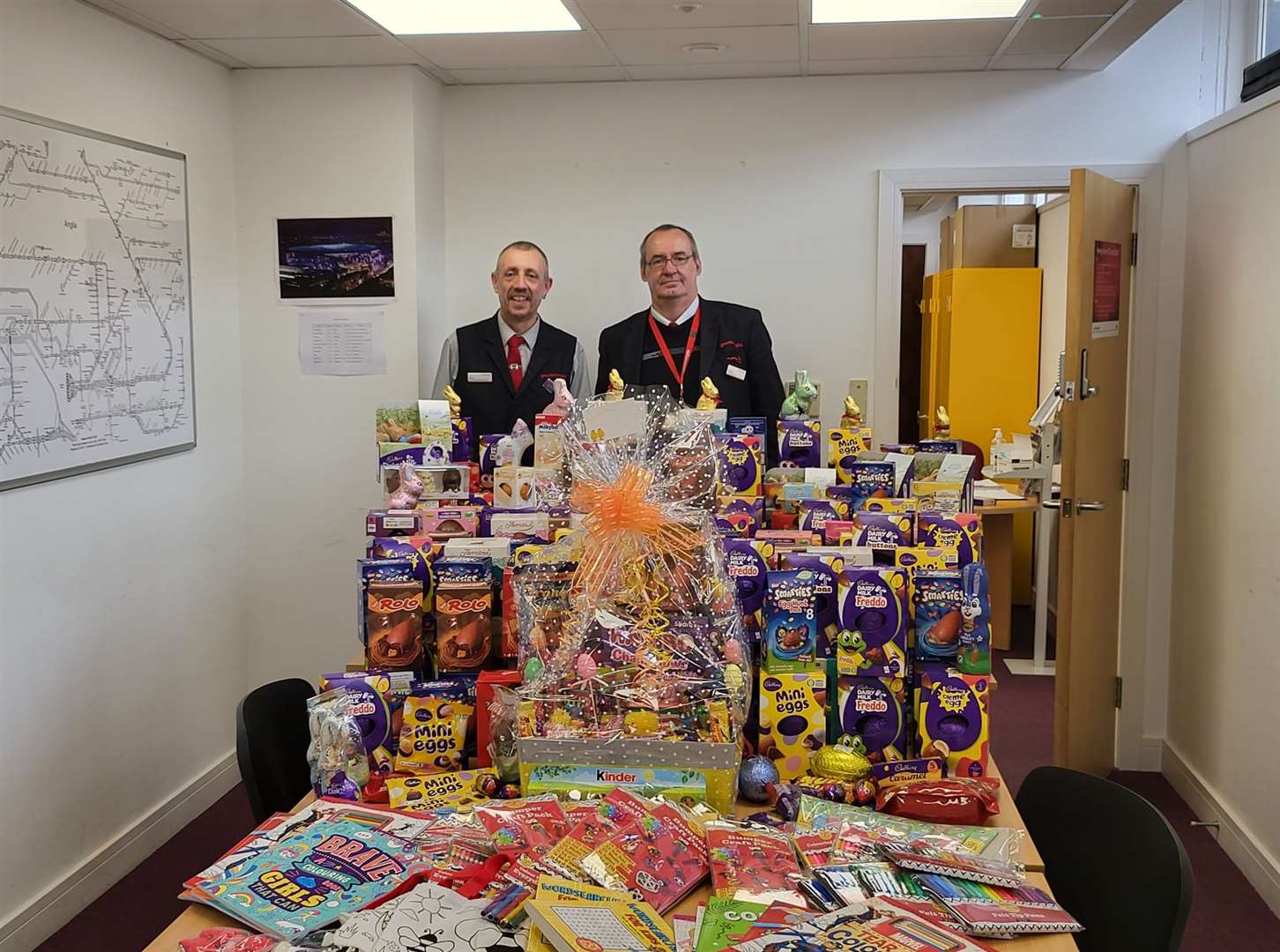 Simon Pope, relief ticket office supervisor (left) and Michael King, relief ticket office clerk (right) with a pile of donated Easter eggs for children in hospital (Greater Anglia/PA)