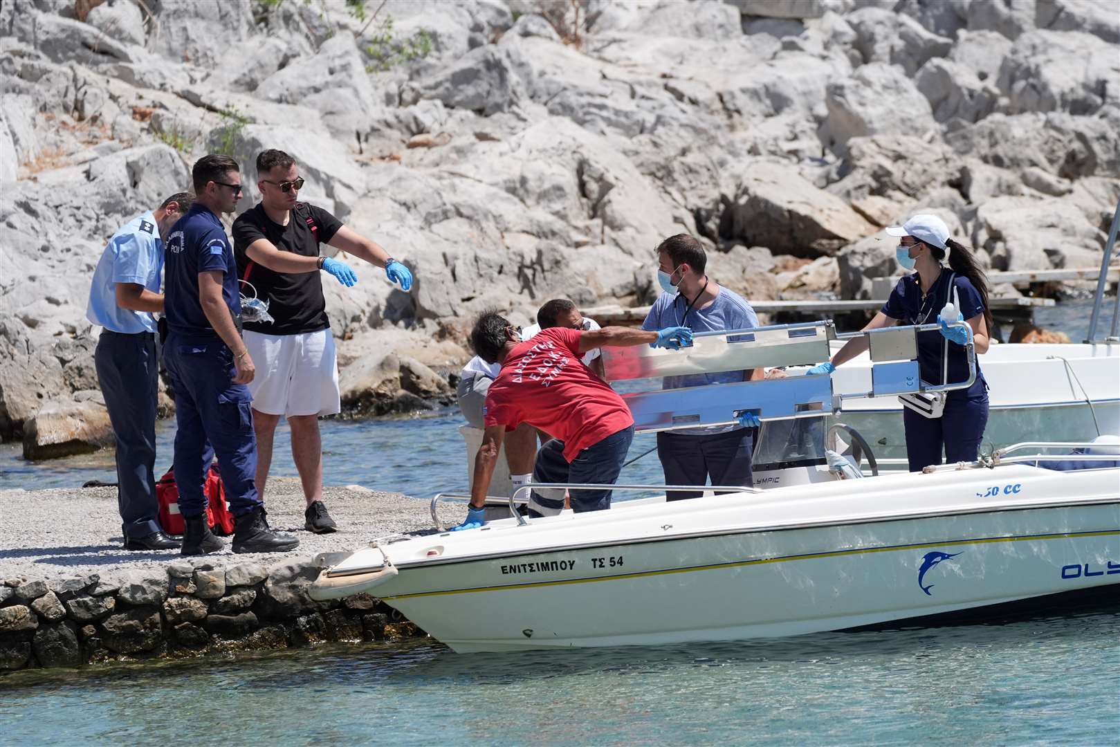 Emergency services lifting an empty stretcher from a boat at Agia Marina (Yui Mok/PA)