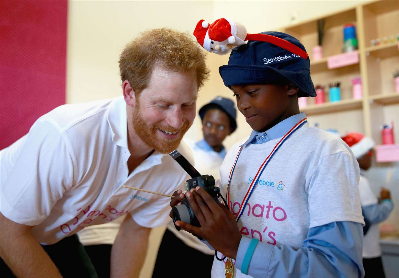 Harry helps a boy during a photography activity in Maseru (Chris Jackson/Sentebale/PA)