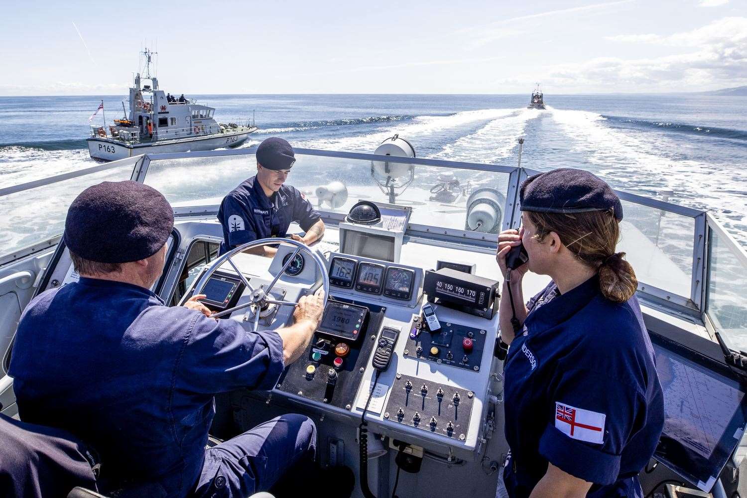 Commanding Officer Lt Rebecca Anderson Royal Navy (right) abroad HMS Biter with CPO (ETME) Graeme Hinton at the helm and AB (SEA) Ryan Dargue during Ship’s in Company Close-in Manoeuvring along the Co Antrim coastline (Liam McBurney/PA)