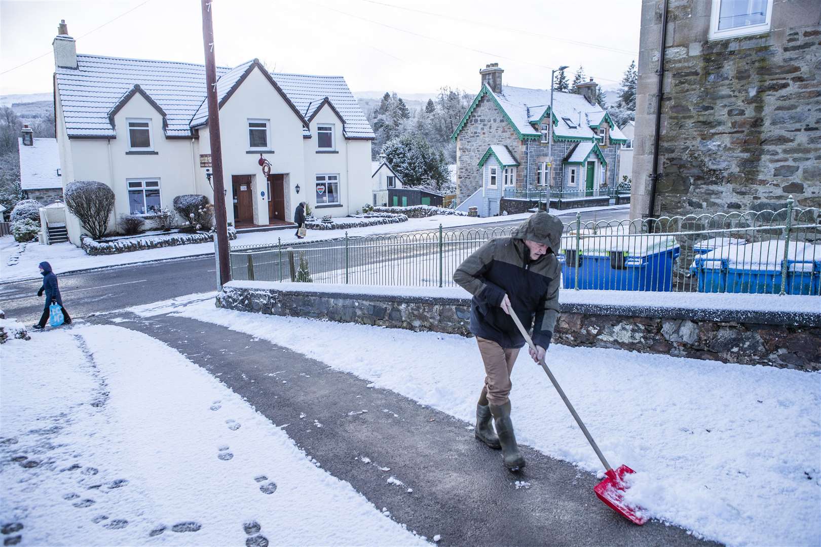 A man clears snow from a driveway in Killin, Stirlingshire (Jane Barlow/PA)