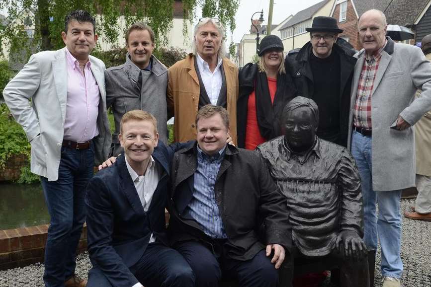 Family and friends pose with the statue