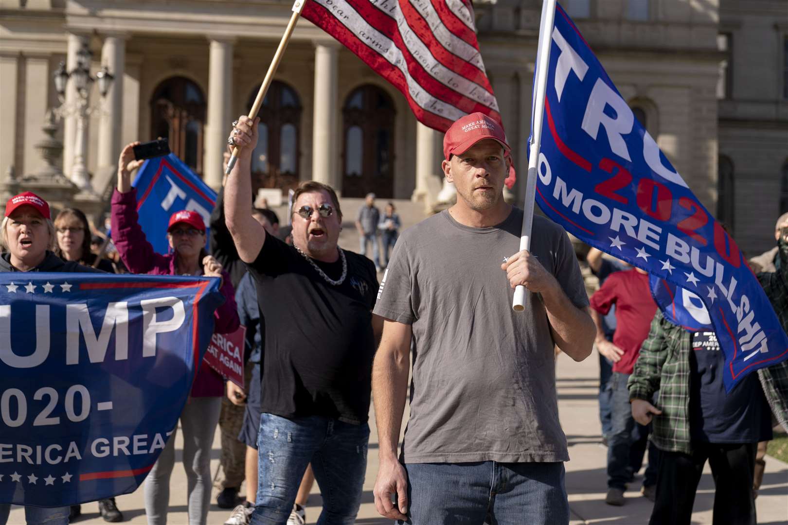 Trump supporters demonstrating over the election results face off with counter protesters at the State Capitol in Lansing (David Goldman/AP)