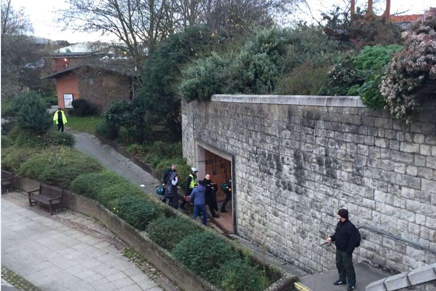 Paramedics move man through the underpass towards High Street