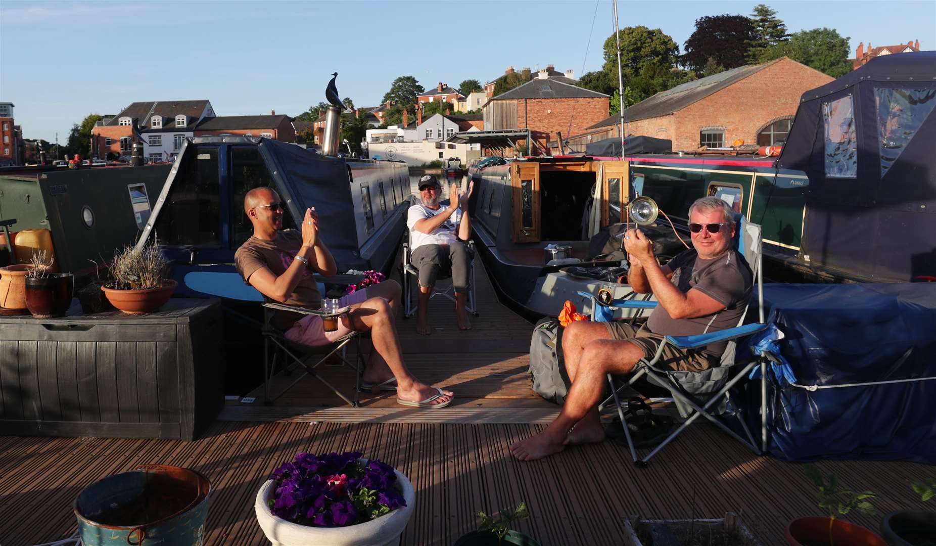 Residents of Diglis Basin in Worcester come out from their boats to join in the weekly Clap for Carers (David Davies/PA)