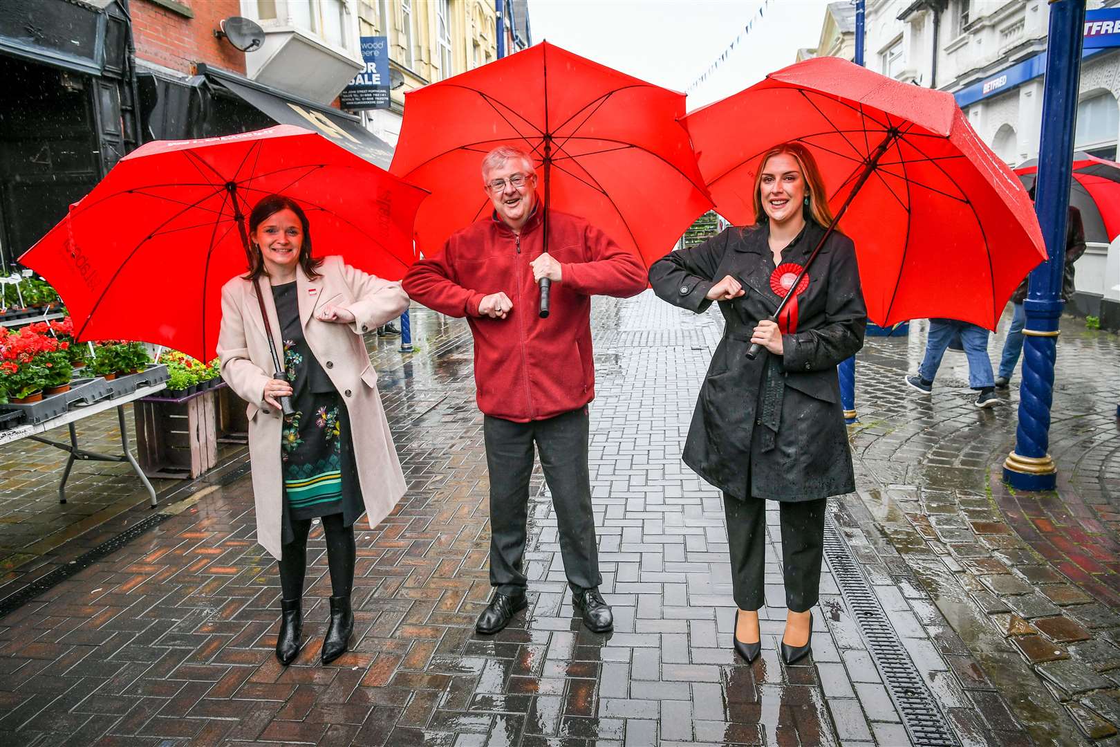 Wales First Minister Mark Drakeford elbow-bumps newly elected MS Labour candidates Elizabeth Buffy Williams, left, and Sarah Murphy in Porthcawl (Ben Birchall/PA)