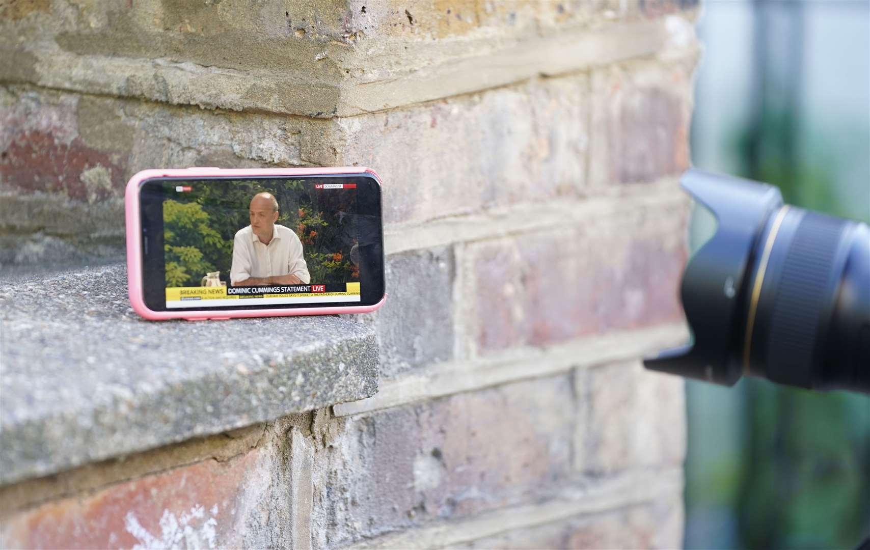 A member of the press photographs a mobile phone (Aaron Chown/PA)