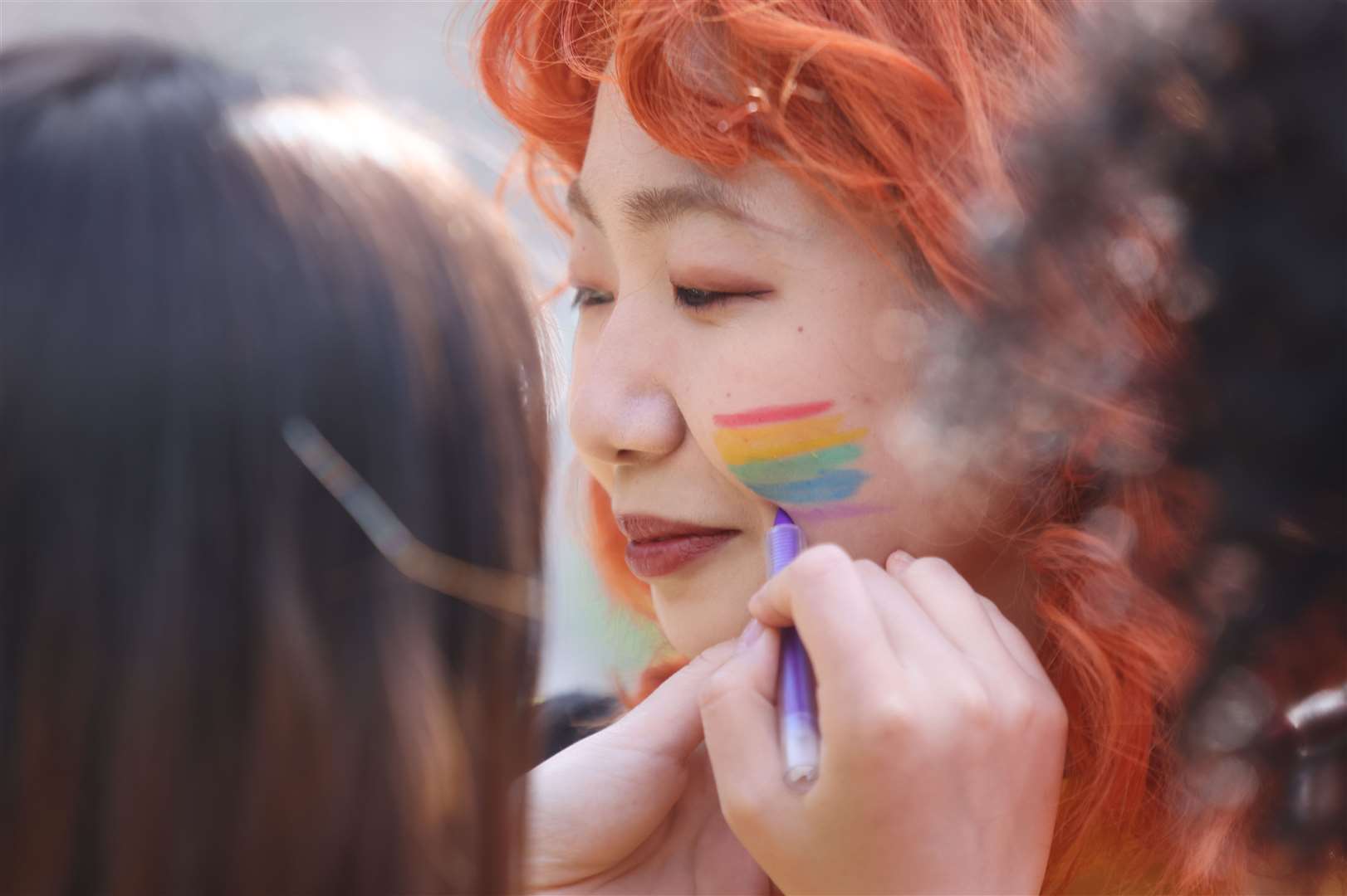 Pride volunteers paint each other’s faces (James Manning/PA)