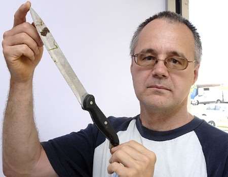 Mark Justice shows the knife which was thrown into his garden