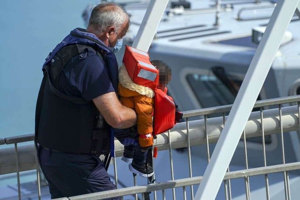 A tiny child is lifted to safety Picture: Steve Parsons/PA