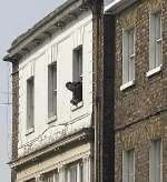 Matthew Titterton at the window of the flat during the stand-off. Picture: BARRY CRAYFORD