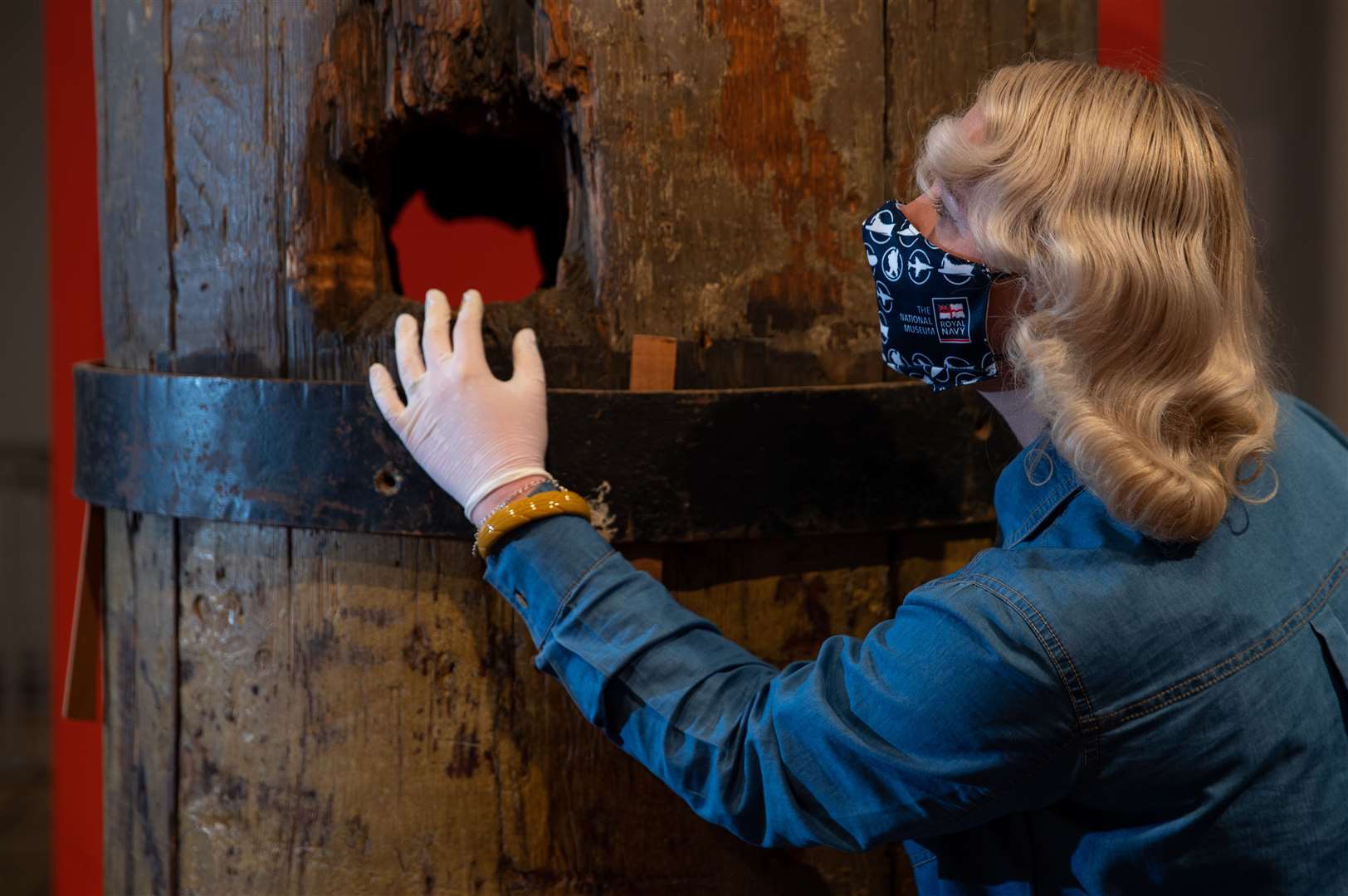 Alice Roberts-Pratt, of the National Museum of the Royal Navy, studies a section of the original wooden foremast from HMS Victory (Andrew Matthews/PA)