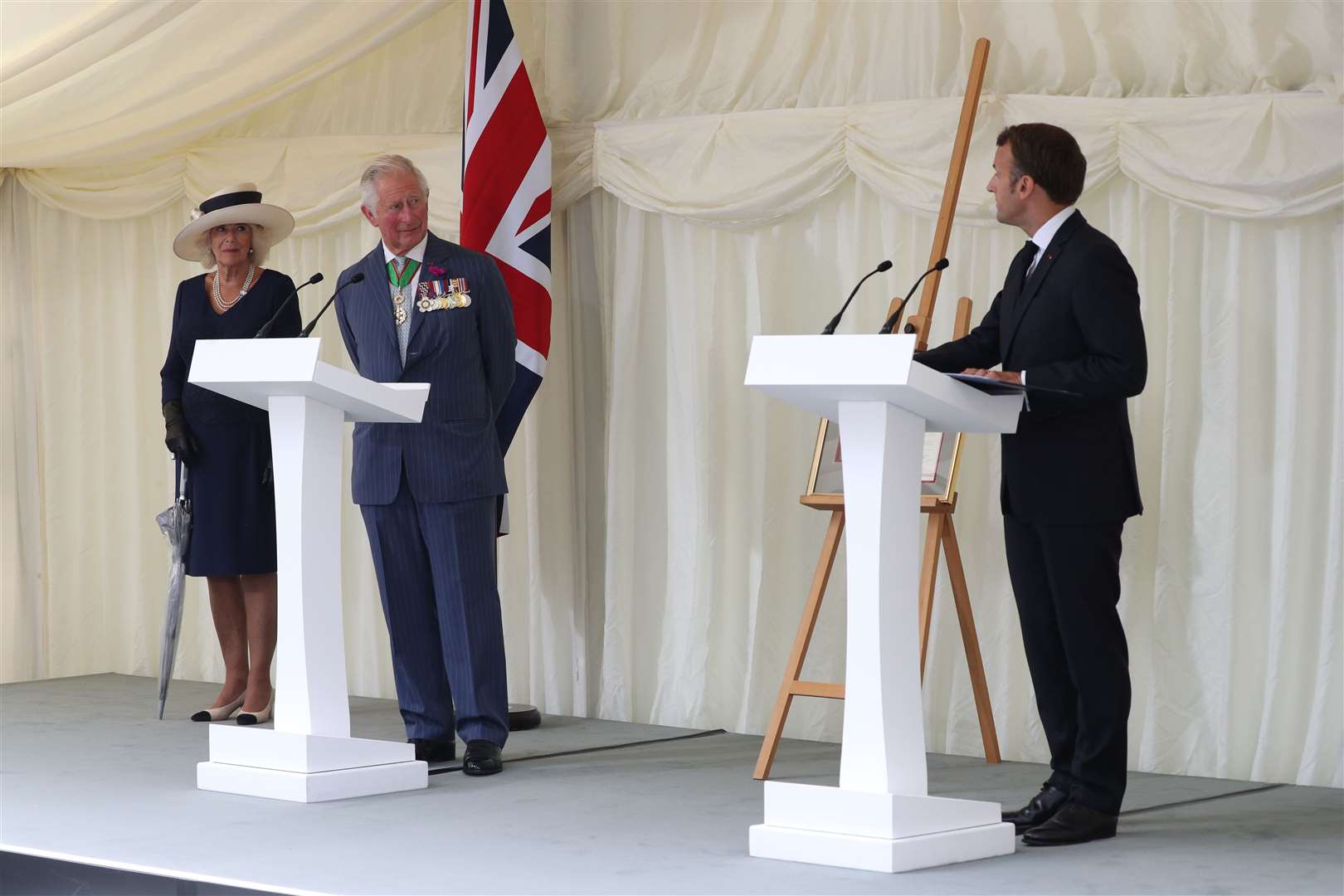 The Duchess of Cornwall and the Prince of Wales alongside French president Emmanuel Macron as he delivers a speech during a ceremony at Carlton Gardens in London (Jonathan Brady/PA)