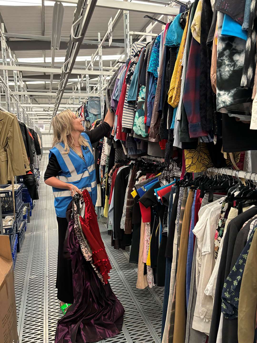 Bay Garnett searches through the rails of an Oxfam warehouse in Milton Keynes (Oxfam/PA)