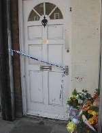 Floral tributes outside the premises where the body was found. Picture: PETER BARNETT