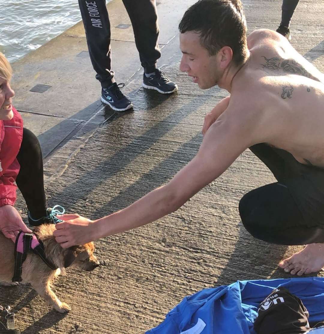 Llewan stroking the dog after he managed to rescue it. Picture: Kyron Rolfe