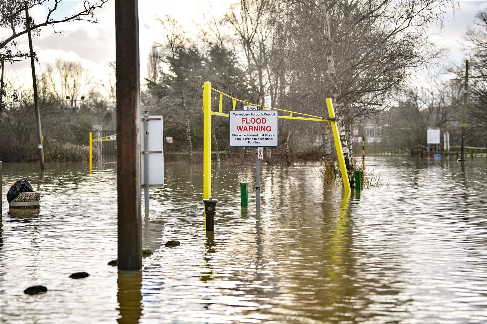 A flood warning sign at the entrance to a flooded car park beside Tewkesbury Abbey, where flood watches were in place (Ben Birchall/PA)