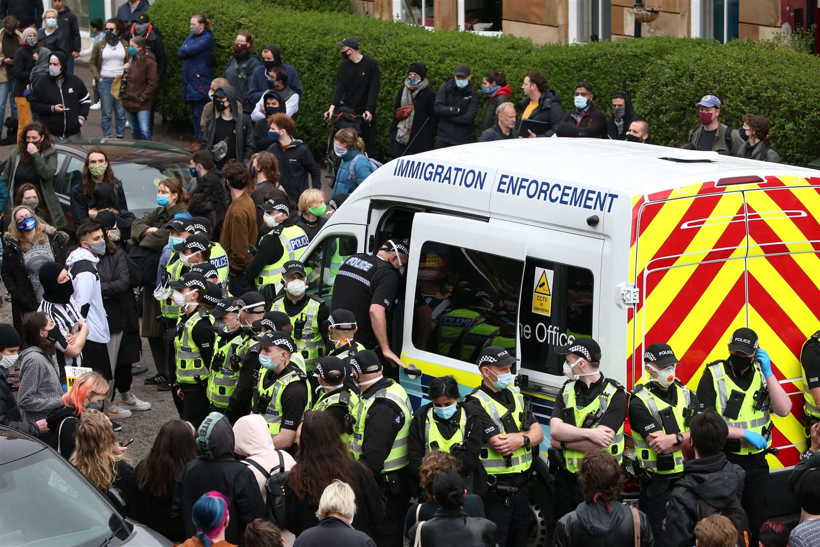 An immigration van in Kenmure Street, Glasgow, surrounded by protesters (Andrew Milligan/PA)