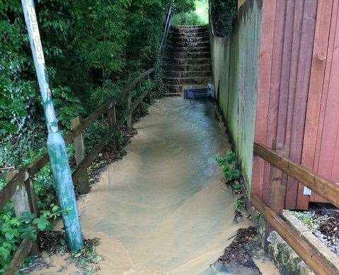 A torrent of water poured down the steps leading into The Beams