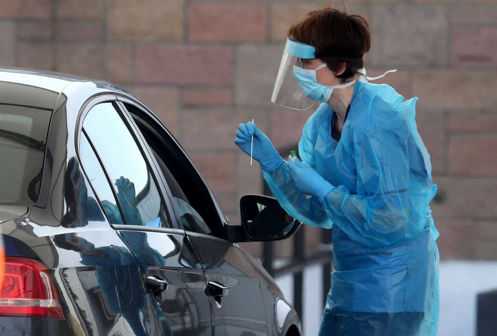 A nurse prepares to take a sample at a Covid-19 testing centre in the car park of the Bowhouse Community Centre in Grangemouth (Andrew Milligan/PA)