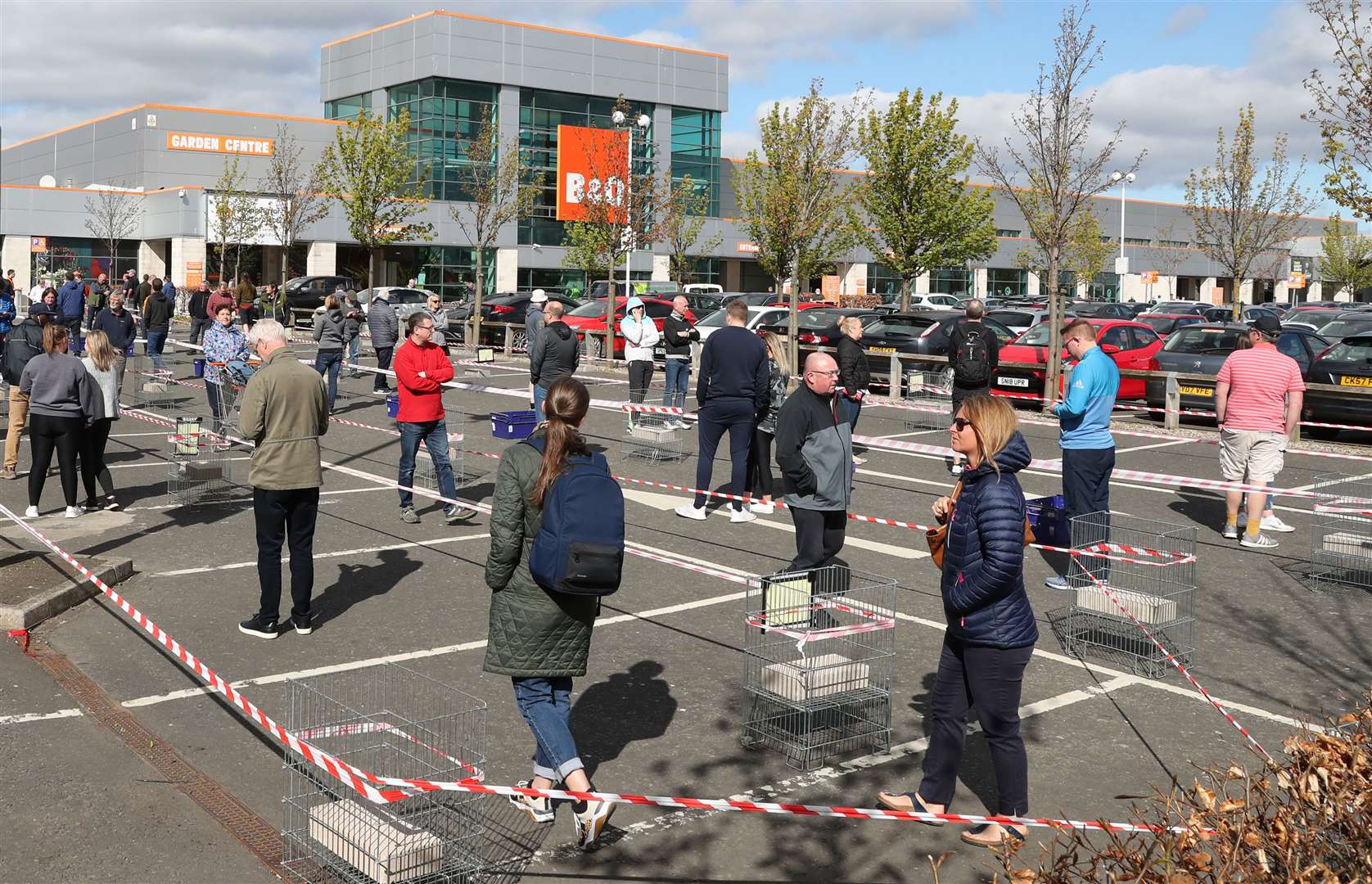 Members of the public follow social- distancing guidelines and queue in the car park of a B&Q in Edinburgh (Andrew Milligan/PA)