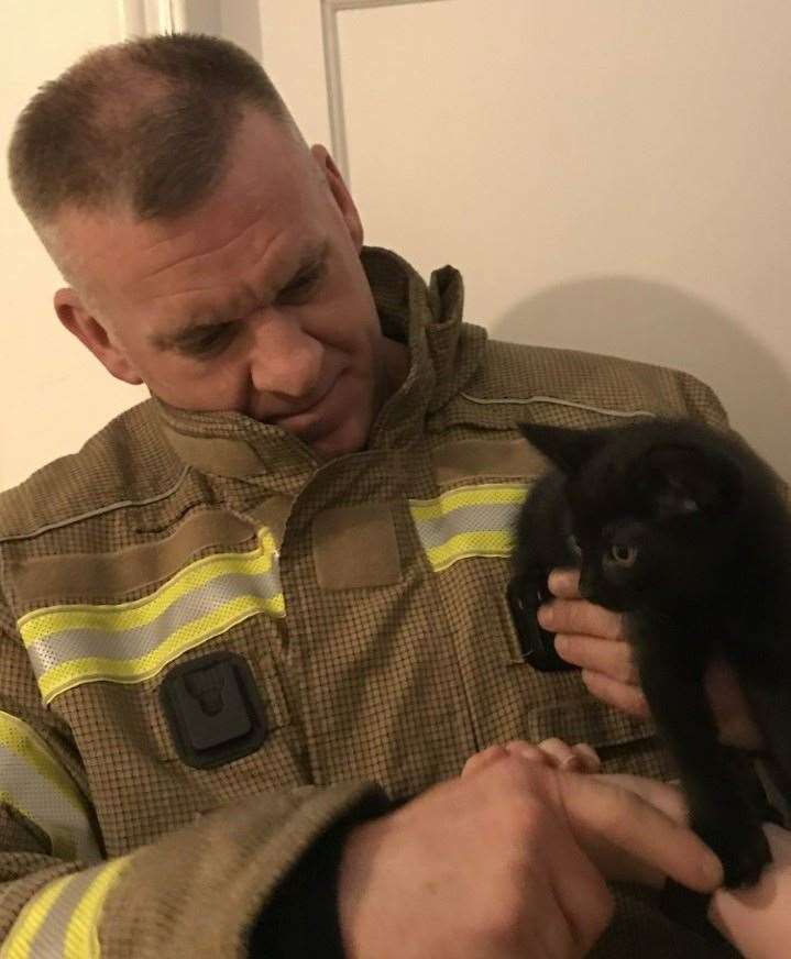 Firefighter Paul Simpson with Tubs the kitten after he was rescued from behind a bathroom wall (Tyne and Wear Fire and Rescue Service/PA)