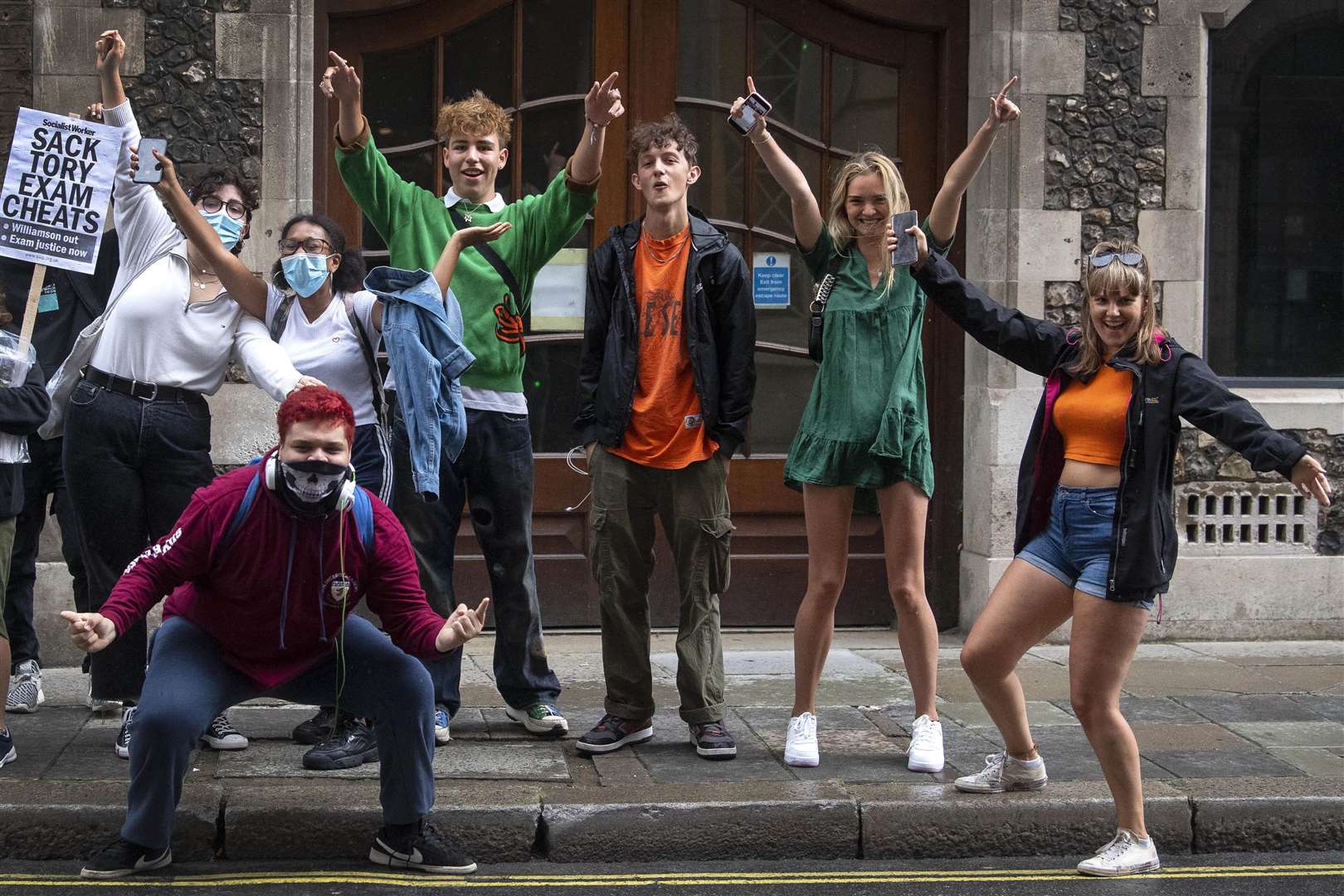 A-level students celebrate after it was confirmed that candidates in England will be given grades estimated by their teachers, rather than by an algorithm (Victoria Jones/PA)