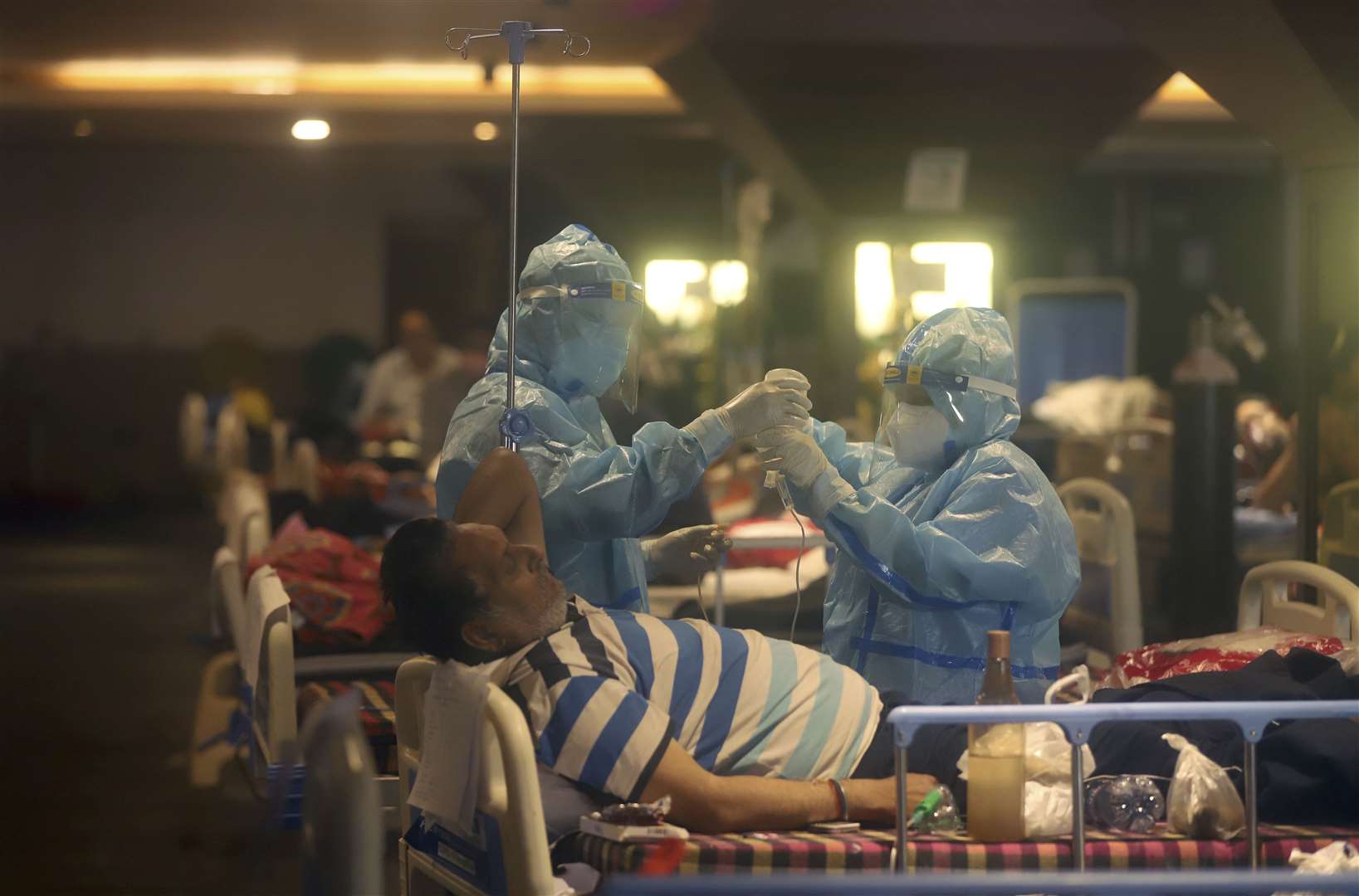 Health workers attend to Covid-19 patients at a makeshift hospital in New Delhi (AP)