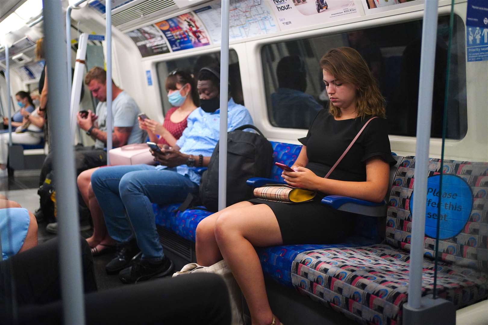 Commuters, some not wearing face masks, on a train (Victoria Jones/PA)