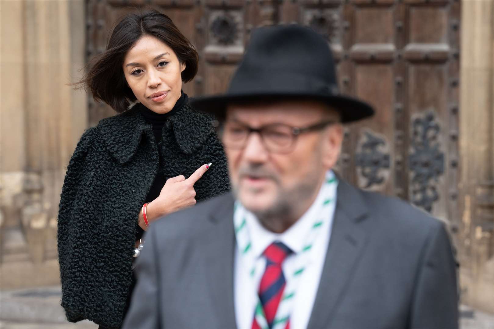 Putri Gayatri Pertiwi watches on as her husband George Galloway speaks to the media outside the Houses of Parliament in London (Stefan Rousseau/PA)