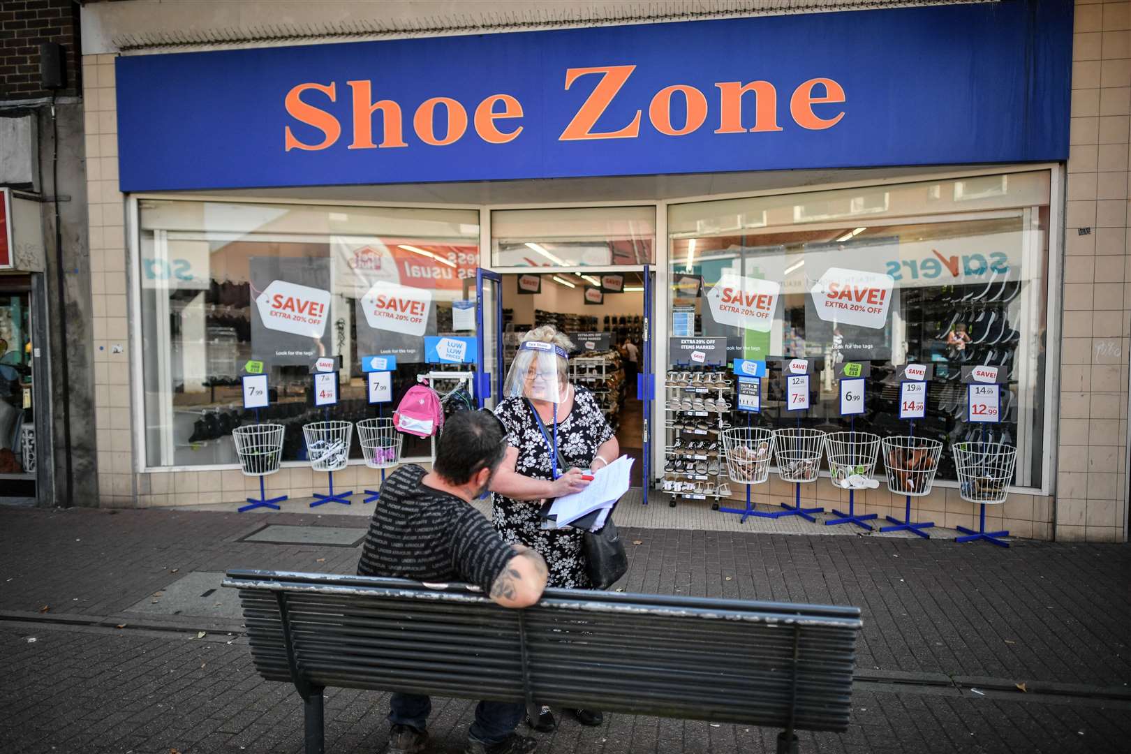 A woman wears a full face visor as she conducts a survey in the relatively empty shopping area of East Street, Bedminster, Bristol (Ben Birchall/PA)