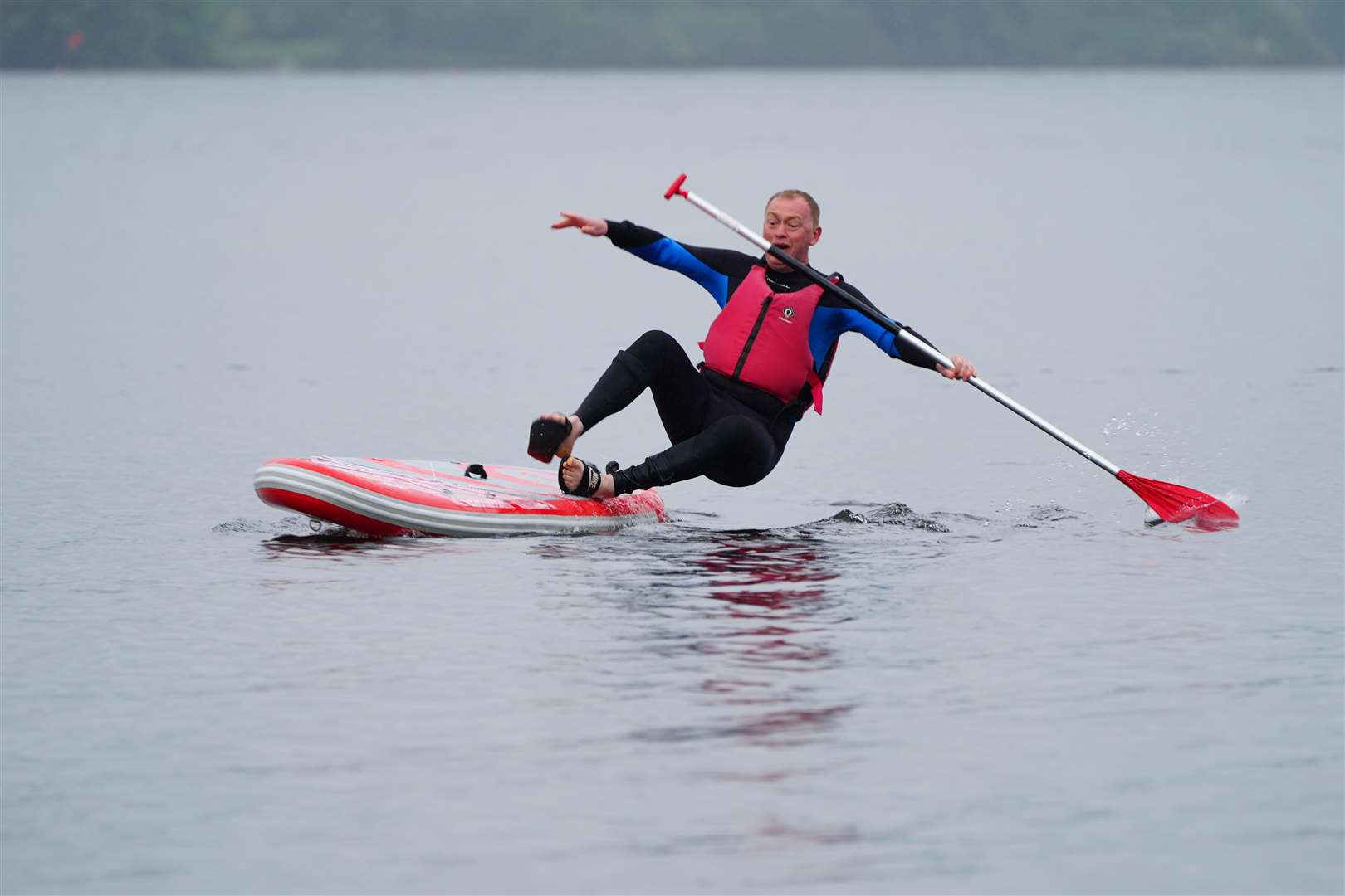 Local Liberal Democrat candidate Tim Farron falls in while paddleboarding on Windermere (Peter Byrne/PA)