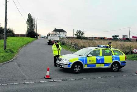 Police guard the entrance to the site where the caravan caught fire